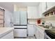 Well-lit kitchen featuring white cabinetry, modern appliances and stainless steel sink at 27622 Lois Dr, Tavares, FL 32778