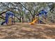 Playground with slides, climbing structures, and covered platforms under large oak trees at 27622 Lois Dr, Tavares, FL 32778