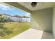 Covered back porch with ceiling fan, overlooking a grassy, fenced backyard on a sunny day at 330 Pheasant Dr, Haines City, FL 33844