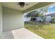 View from the covered back porch to the fenced backyard, featuring lush green grass and a tree at 330 Pheasant Dr, Haines City, FL 33844