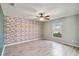 Neutral bedroom with a brick accent wall, ceiling fan, and a view out the window at 330 Pheasant Dr, Haines City, FL 33844