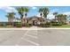 Community clubhouse featuring palm trees, a gated entrance, and parking at 330 Pheasant Dr, Haines City, FL 33844