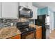 Kitchen features sleek black appliances and beautiful tiled backsplash at 330 Pheasant Dr, Haines City, FL 33844