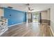 Bright living room with wood-look flooring, a ceiling fan, and sliding glass doors to the backyard at 330 Pheasant Dr, Haines City, FL 33844