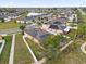 Aerial view showcasing neighborhood homes with solar panels, surrounded by lush greenery and a tranquil pond at 3337 Reedy Glen Dr, Kissimmee, FL 34758