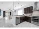 Modern kitchen featuring stainless steel appliances, dark cabinetry, and a seamless transition to the living area at 3337 Reedy Glen Dr, Kissimmee, FL 34758