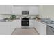 Modern kitchen with white cabinets, granite countertops, and stainless steel appliances at 3534 Fort Mellon Ln, Sanford, FL 32773