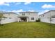 Expansive backyard featuring green grass, a white fence, and covered patio at 4104 Southern Vista Loop, St Cloud, FL 34772