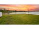 Scenic backyard view with a large pond and a beautiful sunset at 4104 Southern Vista Loop, St Cloud, FL 34772