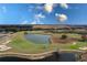 Expansive golf course aerial with serene pond, lush green fairways, and well-placed sand traps offering an inviting landscape at 421 Boxwood Dr, Davenport, FL 33837