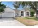 Inviting single-story home with a two-car garage and mature trees in a manicured front yard at 421 Boxwood Dr, Davenport, FL 33837