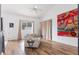 Bright living room features wood-look floors, a ceiling fan, and a vibrant abstract painting at 421 Boxwood Dr, Davenport, FL 33837