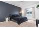 This main bedroom features a dark accent wall, carpet flooring, and a light-filled window with neutral colored curtains at 421 Boxwood Dr, Davenport, FL 33837