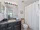 Clean bathroom with dark vanity, shower/tub combo, and white curtain at 4700 Golden Beach Ct, Kissimmee, FL 34746