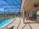 Relaxing pool area with covered patio, outdoor seating, and lake view at 4700 Golden Beach Ct, Kissimmee, FL 34746