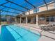 Inviting pool with covered patio and comfortable lounge chairs at 4700 Golden Beach Ct, Kissimmee, FL 34746