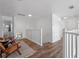 Bright upstairs hallway with wood-look floors, white railings, and comfortable seating area at 4700 Golden Beach Ct, Kissimmee, FL 34746