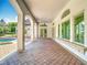 Long covered patio with arched supports and brick flooring at 5067 Latrobe Dr, Windermere, FL 34786