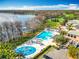 Aerial view of a modern pool area with a splash pad, lounge chairs, and lake views at 5067 Latrobe Dr, Windermere, FL 34786