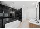 Modern bathroom with luxurious black marble shower, soaking tub, and double vanity sinks at 5544 Sw 136Th Ave, Ocala, FL 34481