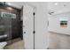 Modern bathroom featuring a frameless glass shower with dark tile and pebble floor, flowing into a spacious, bright tiled room at 5544 Sw 136Th Ave, Ocala, FL 34481