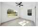 Bedroom featuring a ceiling fan, windows offering views of the yard at 5544 Sw 136Th Ave, Ocala, FL 34481