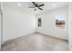 Bright bedroom features neutral tile flooring, two windows for natural light, and ceiling fan for air circulation at 5544 Sw 136Th Ave, Ocala, FL 34481