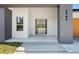 Close-up of the modern home's entrance, showcasing a stylish door and minimalist landscaping at 5544 Sw 136Th Ave, Ocala, FL 34481