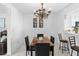 Elegant dining area featuring a chandelier, marble table, and bar access at 564 Shadow Glenn Pl, Winter Springs, FL 32708