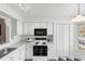 Bright kitchen features white cabinetry, contrasting black appliances, and checkerboard flooring at 564 Shadow Glenn Pl, Winter Springs, FL 32708