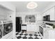 Bright kitchen features black-and-white tile floor, modern appliances, and a laundry area at 564 Shadow Glenn Pl, Winter Springs, FL 32708