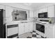 Bright kitchen features white cabinets, black appliances and checkered flooring at 564 Shadow Glenn Pl, Winter Springs, FL 32708
