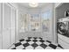 Bright laundry room with checkered flooring and a wall of windows at 564 Shadow Glenn Pl, Winter Springs, FL 32708