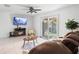 Comfortable living room featuring a ceiling fan, fireplace, a brown leather sofa, and access to the backyard at 564 Shadow Glenn Pl, Winter Springs, FL 32708