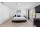 Bright main bedroom with sleek wood-look tile flooring, updated fixtures, and large window at 564 Shadow Glenn Pl, Winter Springs, FL 32708