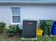 Exterior view of the central AC unit and surrounding landscaping at 594 Terranova Cir, Winter Haven, FL 33884