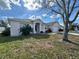 Exterior view of house with mature tree and landscaping at 594 Terranova Cir, Winter Haven, FL 33884