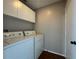 Laundry room with washer, dryer, and overhead cabinets at 594 Terranova Cir, Winter Haven, FL 33884