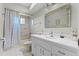 Bright bathroom with a shower-tub combo, decorative mirror, and updated vanity at 616 Mellowood Ave, Orlando, FL 32825