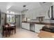 Bright kitchen with white cabinetry, stainless steel appliances, and a cozy dining area by the window at 616 Mellowood Ave, Orlando, FL 32825