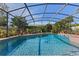 Sparkling blue screened-in pool surrounded by manicured landscaping at 616 Mellowood Ave, Orlando, FL 32825