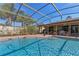 Beautiful screened-in pool with lush landscaping and a clear blue sky at 616 Mellowood Ave, Orlando, FL 32825