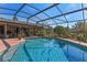 Backyard pool surrounded by a screened enclosure and a patio seating area at 616 Mellowood Ave, Orlando, FL 32825