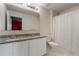 Bright bathroom boasts double vanity with granite countertop and tiled shower featuring a white curtain at 741 Gila Dr, Kissimmee, FL 34759