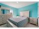 Bright bedroom with blue walls and white bed frame with bedside tables and white tile flooring at 741 Gila Dr, Kissimmee, FL 34759