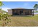 View of the screened in patio with a ceiling fan overlooking a lawn, perfect for outdoor relaxation at 741 Gila Dr, Kissimmee, FL 34759