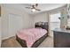 Charming bedroom with a ceiling fan, large window, and a comfortable bed with storage drawers at 812 Gisele Ct, Haines City, FL 33844