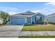 Charming single-story home with blue siding, manicured lawn, and attached two-car garage at 812 Gisele Ct, Haines City, FL 33844