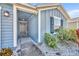 Inviting front porch featuring blue siding, a welcome mat, and decorative landscaping at 812 Gisele Ct, Haines City, FL 33844