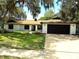 Charming single-story home with a well-manicured lawn and mature trees providing ample shade at 8546 Amber Oak Dr, Orlando, FL 32817